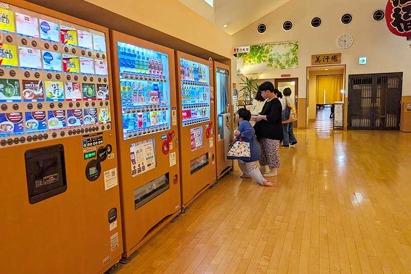 自動販売機でジュースを買う兄弟