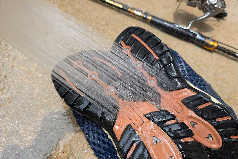 シャワーで洗っているマリンシューズ